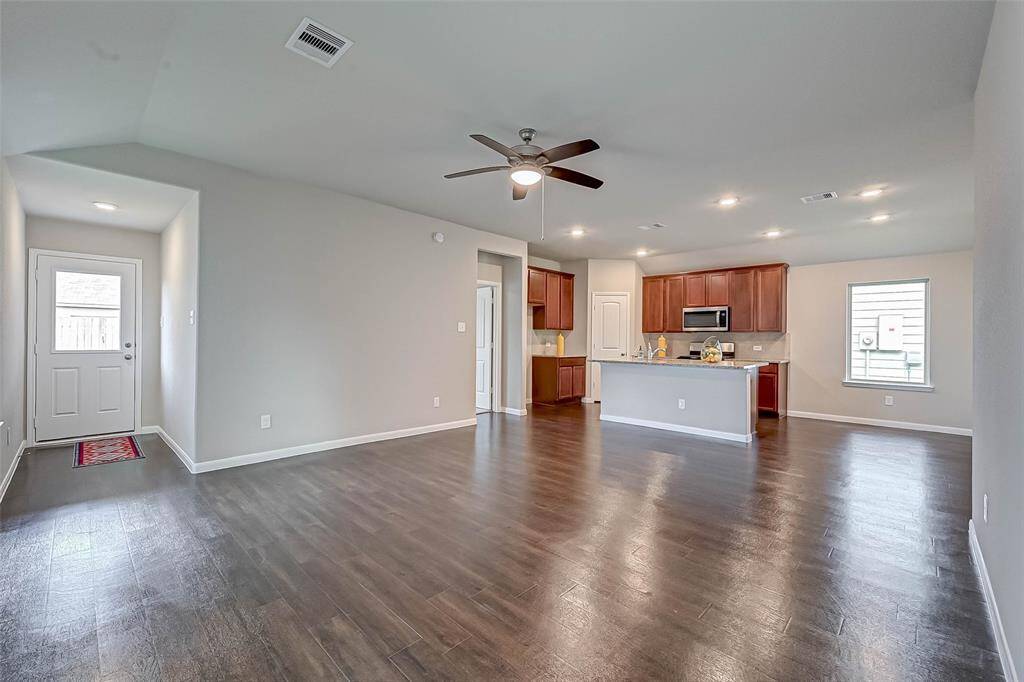 Open-concept layout creates a natural flow between the expansive living room, dining area, and kitchen.