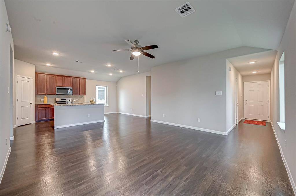 Open-concept layout creates a natural flow between the expansive living room, dining area, and kitchen.