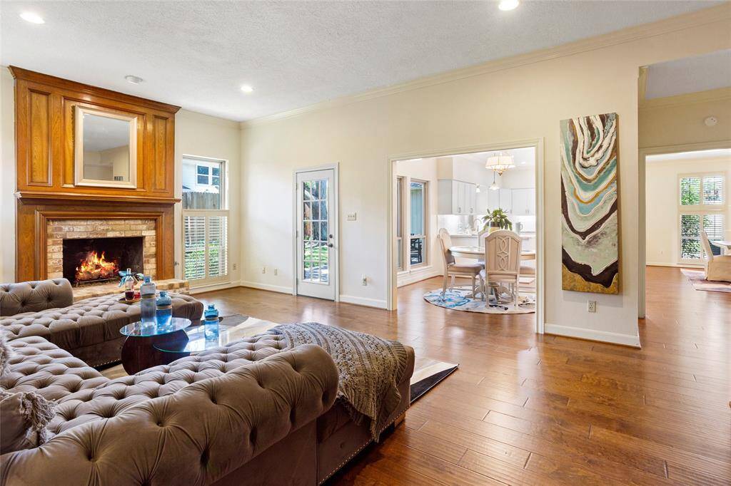 Family room is huge with wood and brick gas fireplace, access to backyard, wood flooring throughout...