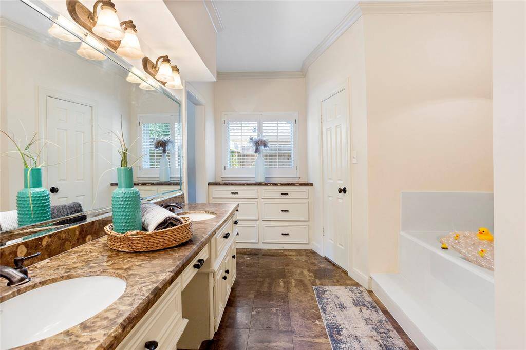 FIRST primary bathroom located on the first floor has built in drawers, 2 walk-in closets, double sinks, granite countertops...