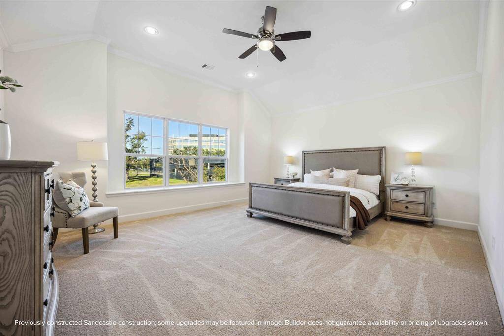Step into a primary suite that lives like a luxury retreat—soaring ceilings, soft carpet underfoot, and a wall of windows bringing the outside in.