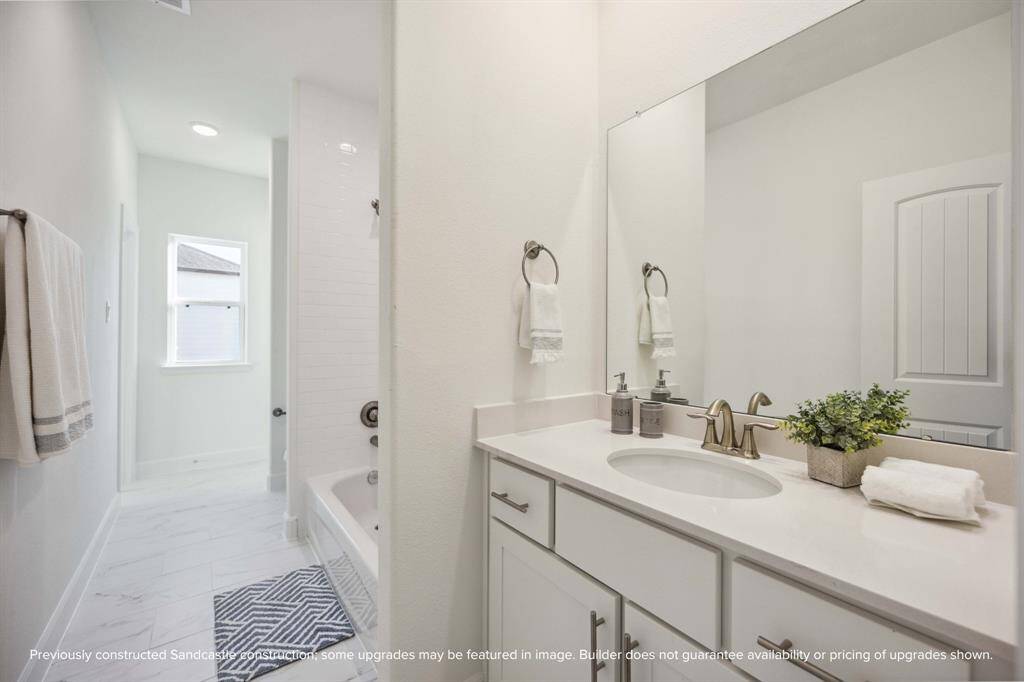 Flooded with light and finished with care, this hall bath delivers both function and finesse. Bonus points for that deep tub and elevated tilework.
