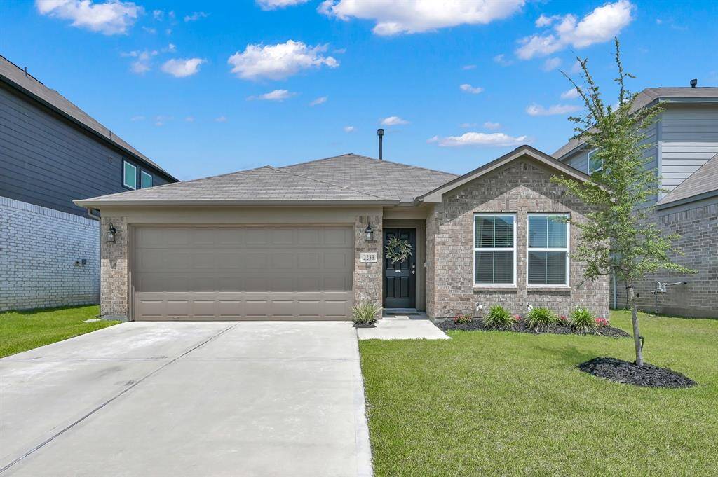 This charming single-story home features a brick exterior with a two-car garage and well-maintained front yard landscaping.