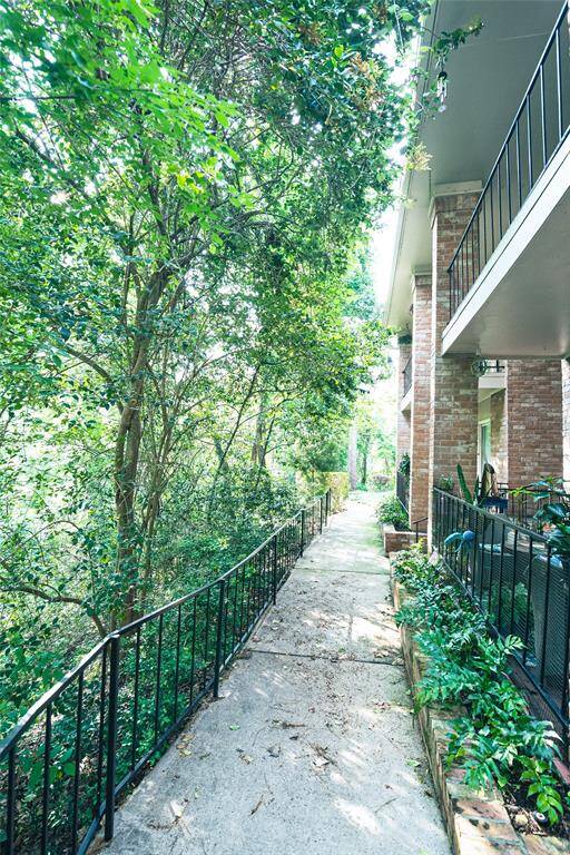 Charming walkway leading to the condo, set alongside a serene natural landscape—offering a peaceful transition from the outdoors to your front door.