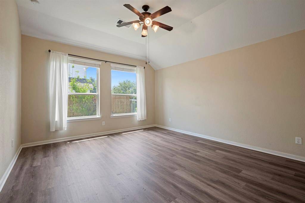 The spacious primary bedroom has views of the backyard