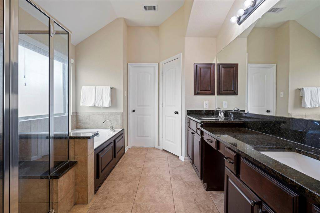 The primary bath features dual sinks, vanity space, soaking tub and separate shower.