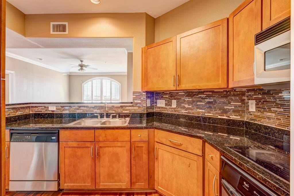 This welcoming entryway leads to an open living area with beautiful hardwood floors and abundant natural light from large windows. The space features warm tones and elegant crown molding, creating a cozy yet stylish atmosphere.