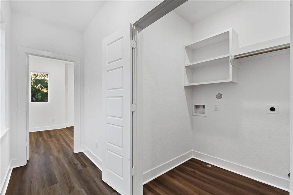 The upstairs laundry room is equipped with washer and dryer connections, as well as built-in shelving for added convenience.