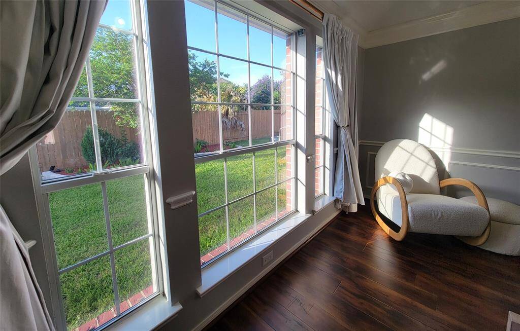 Bright room with large windows overlooking a green backyard.