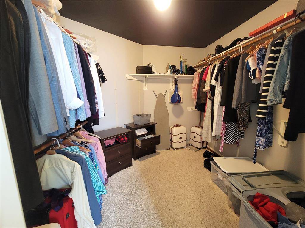 This spacious walk-in closet features ample hanging space, shelving, and storage solutions, providing excellent organization for clothing and accessories.