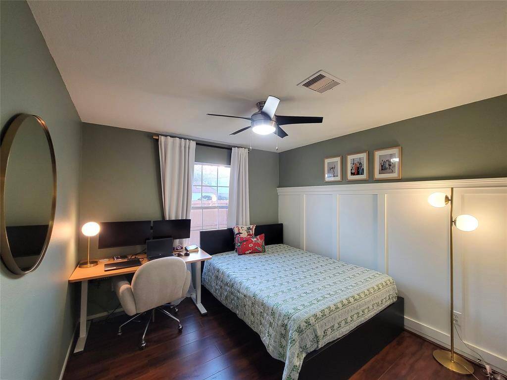 Spacious bedroom with wainscoting on one side and a large closet space.