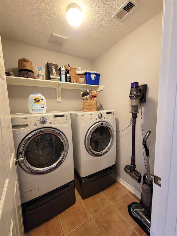 This photo shows a compact laundry room featuring a front-loading washer and dryer set. Washer and Dryer stay!