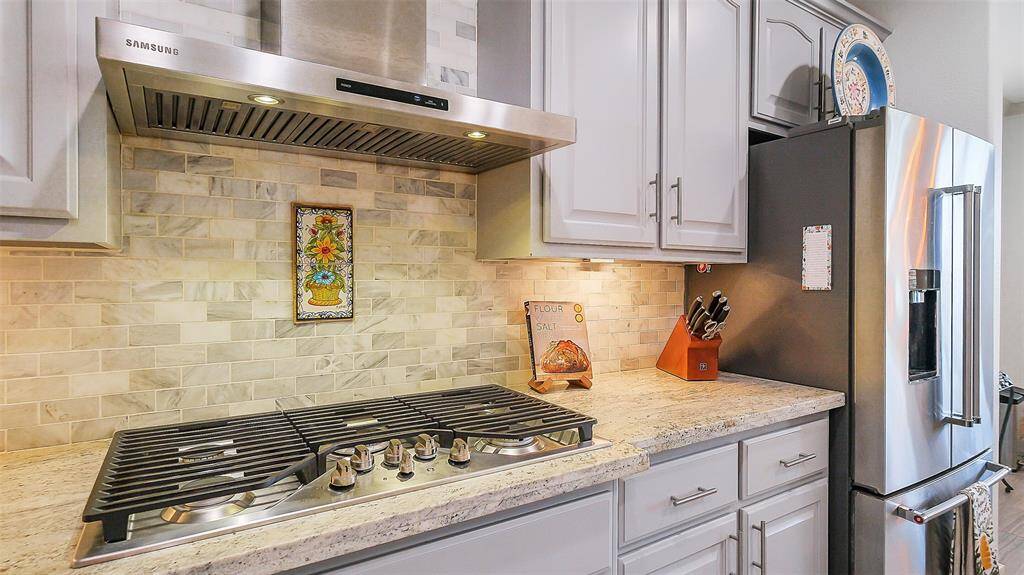 Stainless appliances, undermount lighting, built in microwave and island with a recipe book nook.