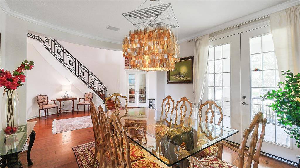Sitting area in the rotunda style grand entry.  Home office/ study through the French doors.  Gleaming real hard wood flooring.  Notice the beautiful stair rail.  Vaulted ceiling entry.