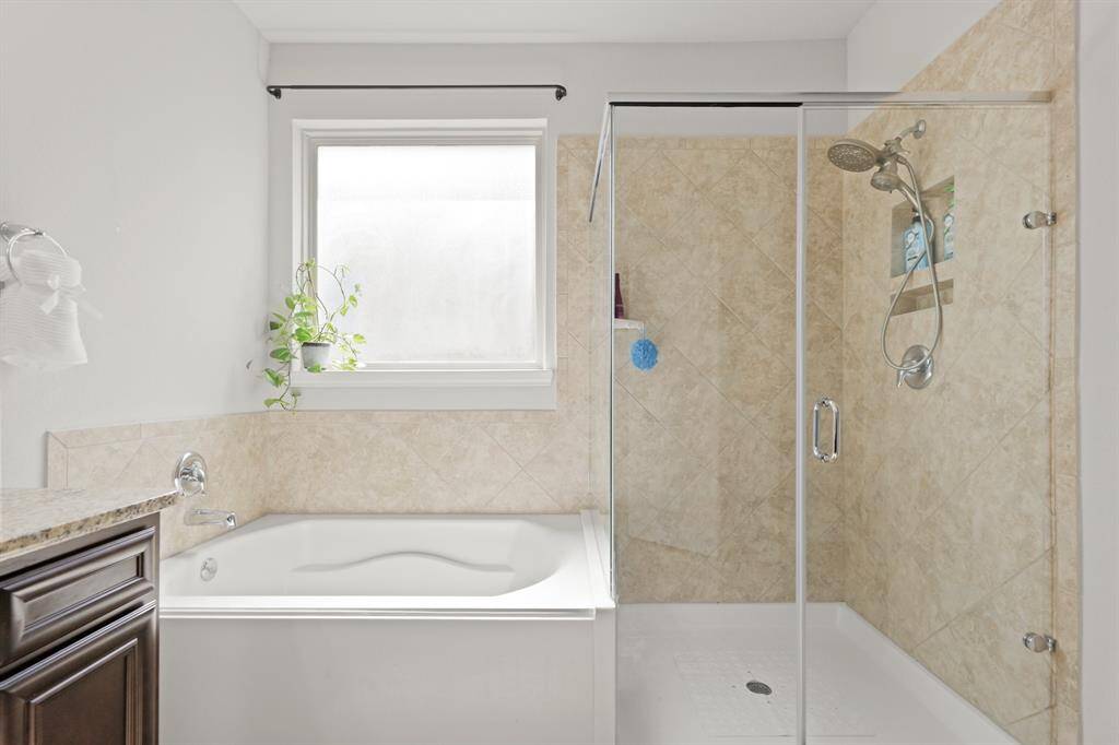 Unwind in the oversized soaking tub or rinse off in the walk-in shower—this en suite is designed for both function and relaxation.