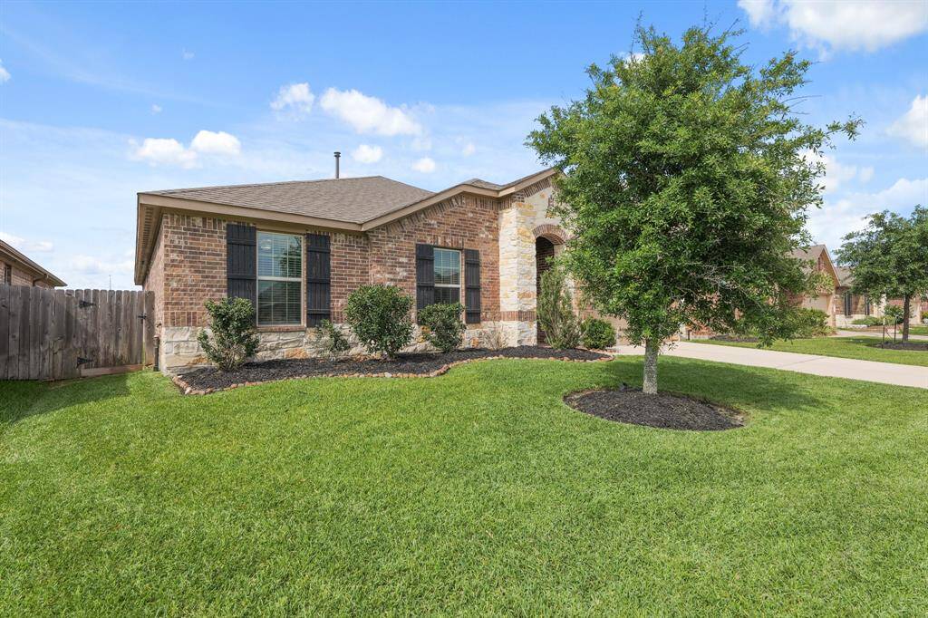 Well-kept yard and mature tree create a welcoming entrance, with side gate access to the backyard.