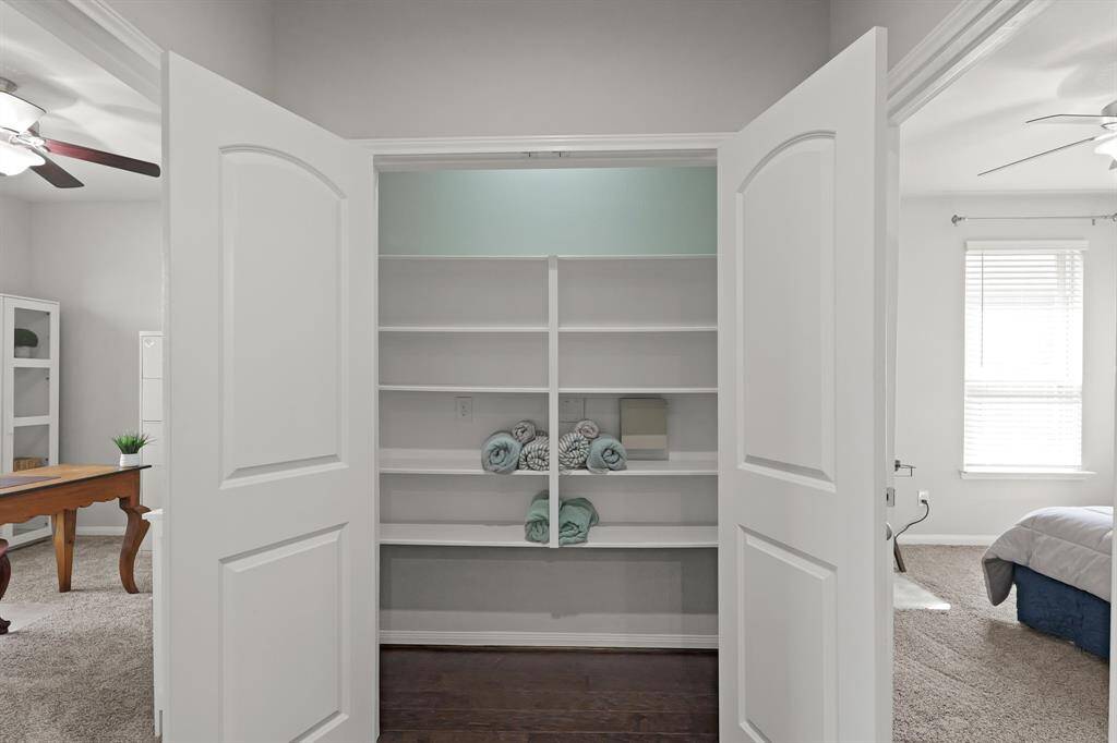 Spacious hallway linen closet offers deep shelving and easy access for storing towels, linens, or overflow supplies.