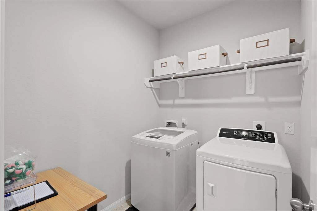 Laundry room just off the entry, with built-in hanging space and room to add storage or a folding table.
