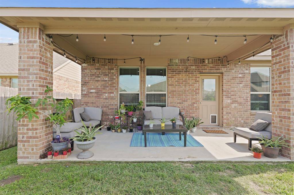 Covered patio with string lights and seating—ready for morning coffee or weekend lounging.