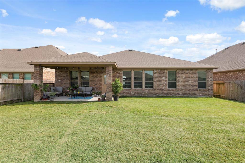 Full view of the brick exterior and extended covered patio, perfect for relaxing or hosting. Notice that you cannot see the solar panels from any angle front or back!