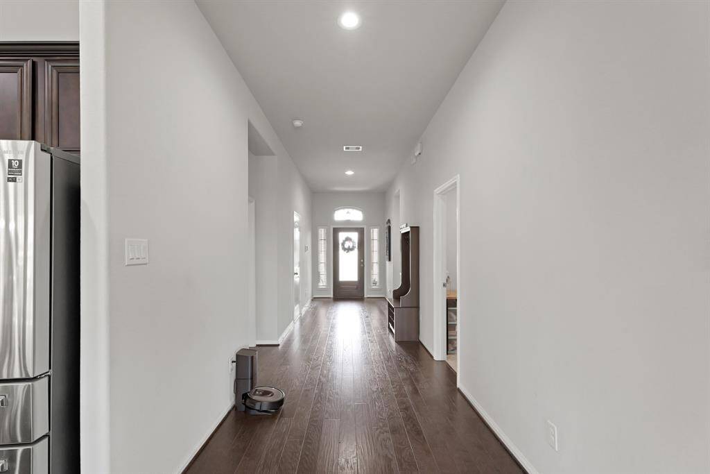 A warm first impression—rich hardwood floors, fresh paint, and natural light greet you right at the door. Just off the entry, the door on the right leads to the laundry room for easy everyday functionality.