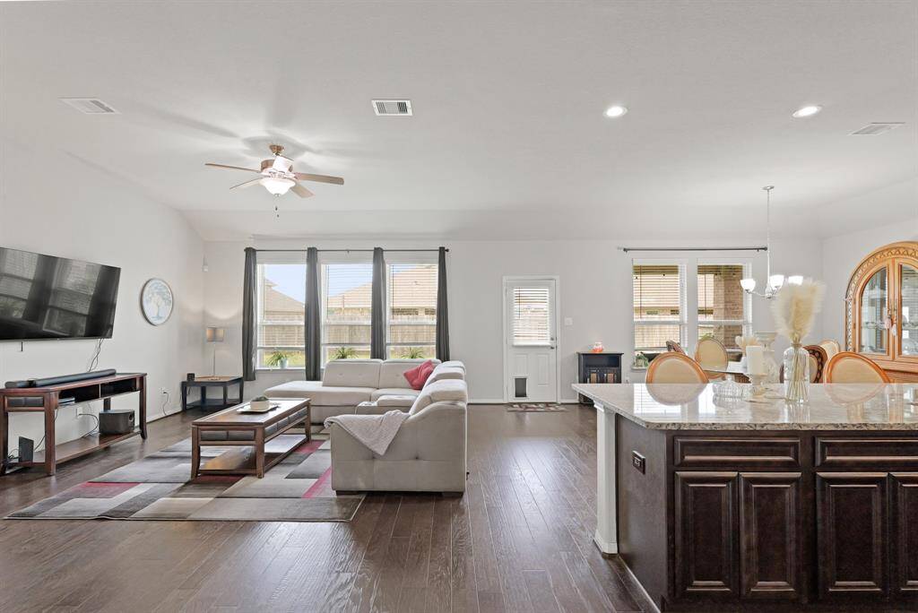 Wall of windows brings in natural light and frames the open-concept living, dining, and kitchen space.