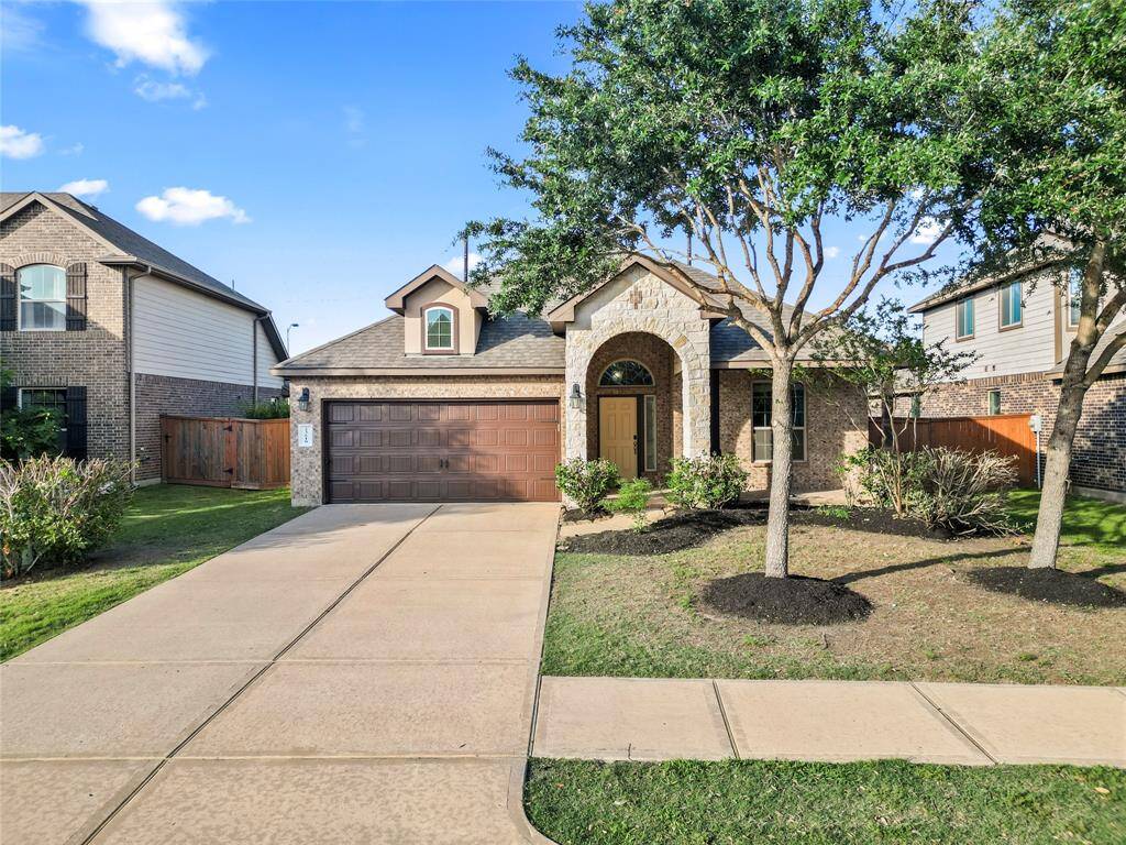 Charming curb appeal and a welcoming arched entryway set the tone for this beautifully maintained brick-and-stone home on Ortensia Street. A spacious driveway and manicured landscaping complete the picture.
