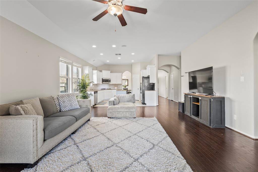 Spacious, sunlit, and designed for connection—this open-concept living room flows seamlessly from the kitchen, making it perfect for hosting or hanging out. Natural light floods in through multiple windows, while recessed lighting and a ceiling fan keep things comfortable day or night. Your element of comfort? The plush, oversized seating area that invites movie marathons, lazy Sundays, or impromptu game nights.