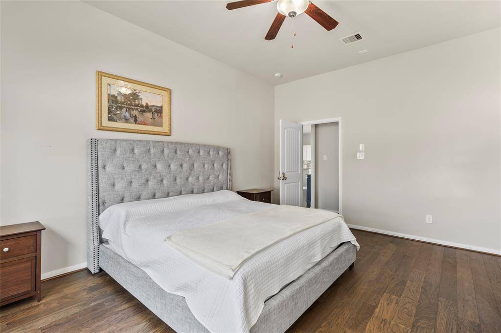 The moment the door closes behind you, this room becomes a retreat. The ceiling fan hums softly overhead, the hardwood floors ground the space with warmth, and the simple layout leaves room to breathe.