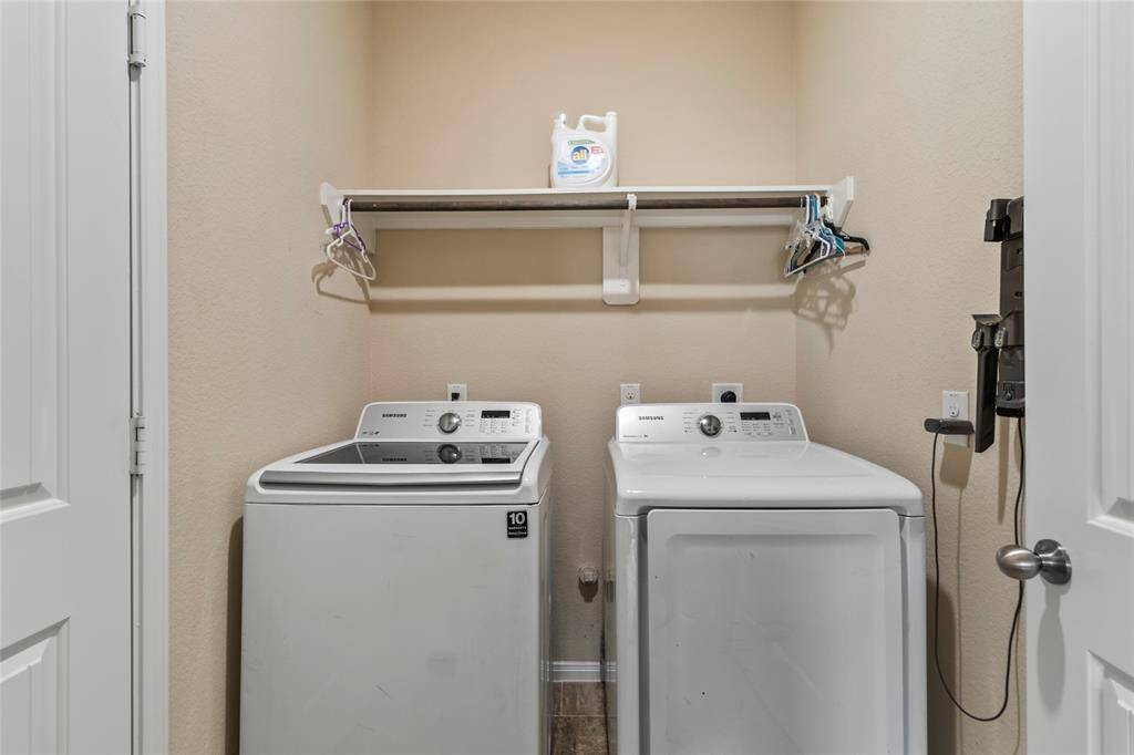 Laundry days feel effortless in this tidy utility room, where everything you need is right within reach—from the overhead shelf for supplies to the ganging rod for air-drying garmets.
