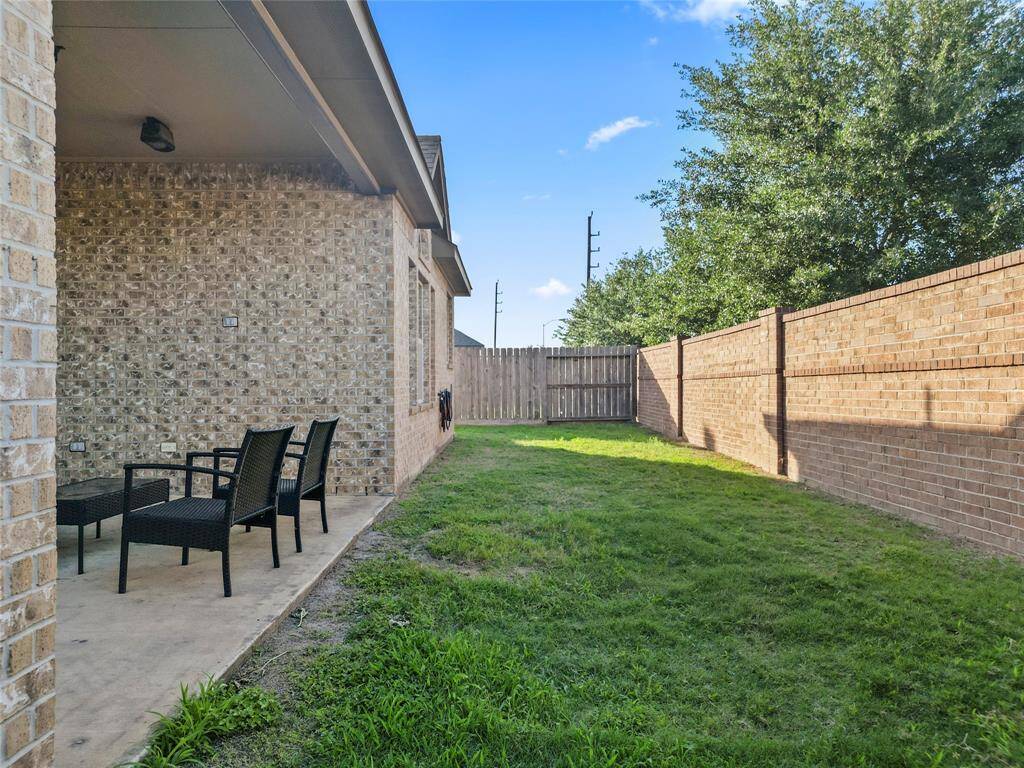 Tucked behind a brick privacy wall, this backyard offers the perfect blend of seclusion and space. Whether you're hosting a laid-back evening on the covered patio or just soaking up a quiet morning, this outdoor retreat brings everyday comfort within reach.