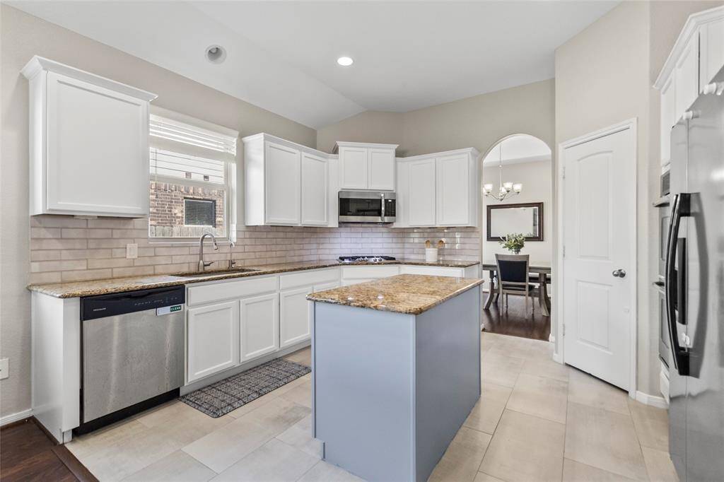 Your kitchen goals, realized. Bright white cabinetry, granite counters, a center island with seating, and stainless steel appliances come together in a space that’s both functional and beautiful. Subway tile backsplash and wide tile flooring add a sleek, timeless touch. And with sightlines into the dining and living areas, you're always part of the conversation.