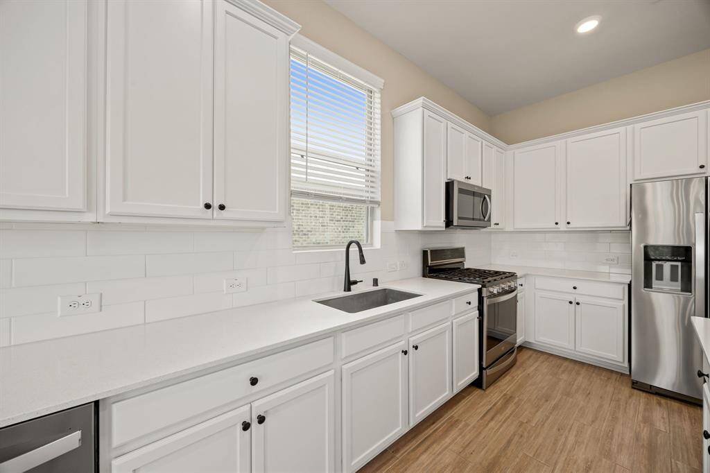 Large farm sink in the kitchen and a view to the side yard. Lots of storage in the kitchen.