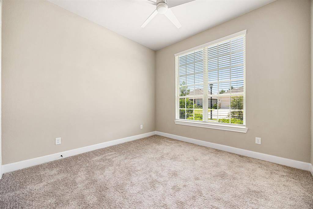 View of the spacious secondary bedroom with plush carpet. Looks out to the front of the home and has it's own bathroom.