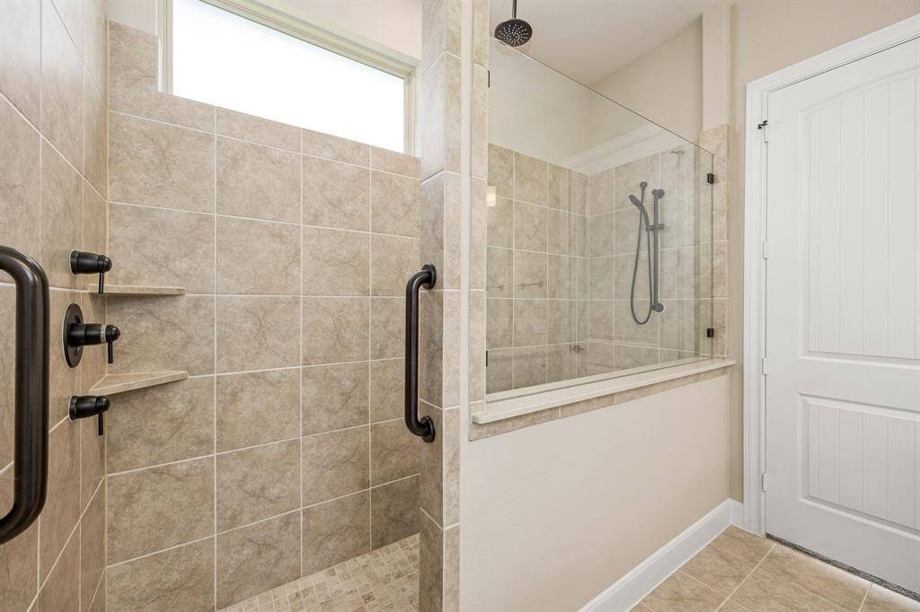 Upgraded tiled walk in super shower equipped with grab bars for safety. Shower is equipped with 2 shower heads including a rain shower.