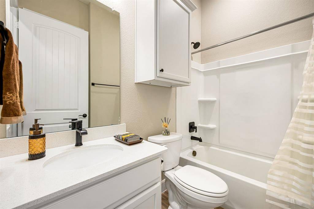 Secondary bathroom with tub\shower combo and accented with bronze fixtures,