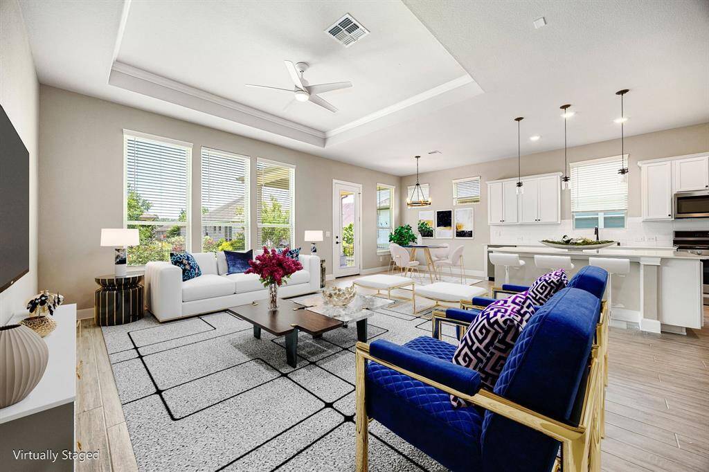 Bright, open-concept living area with a modern kitchen, dining space, and cozy living room. Large windows provide abundant natural light, while neutral tones create a welcoming atmosphere.