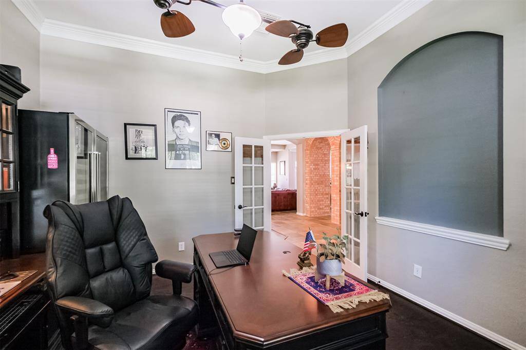 The front study features an art niche, rich wood floors, and refined crown molding.