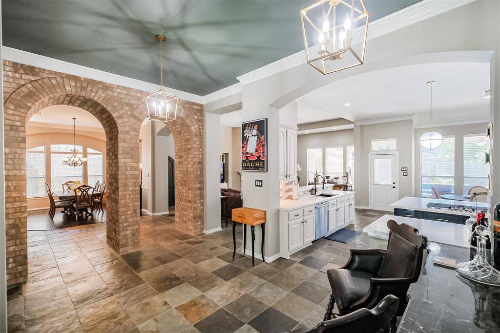 The large brick arches allow flow between the sunroom and the spacious kitchen-living area, perfect for modern living.