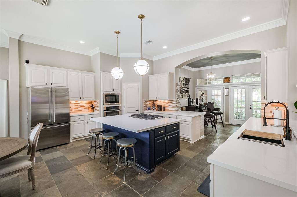 Spacious kitchen breakfast area seamlessly opens to a bright sunroom, perfect for relaxed dining and entertaining.