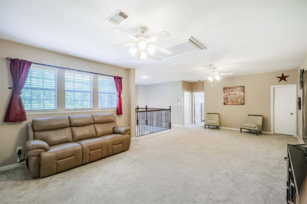 Expansive second-floor game room with large windows for abundant natural light.