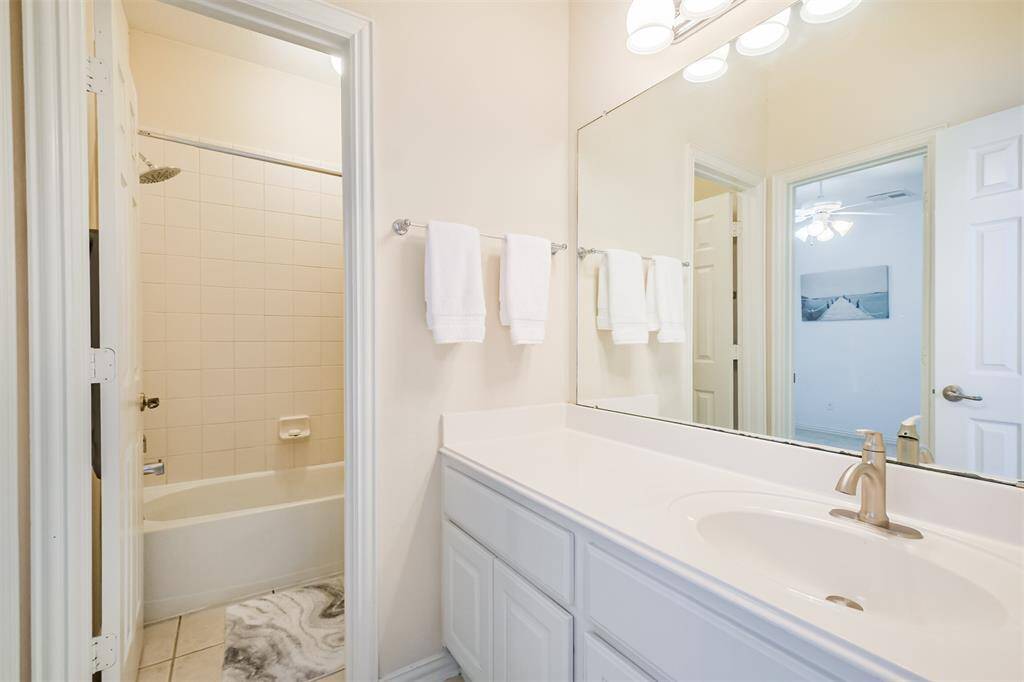 Spacious upstairs bathroom featuring a private tub and toilet room, complemented by a large vanity sink.