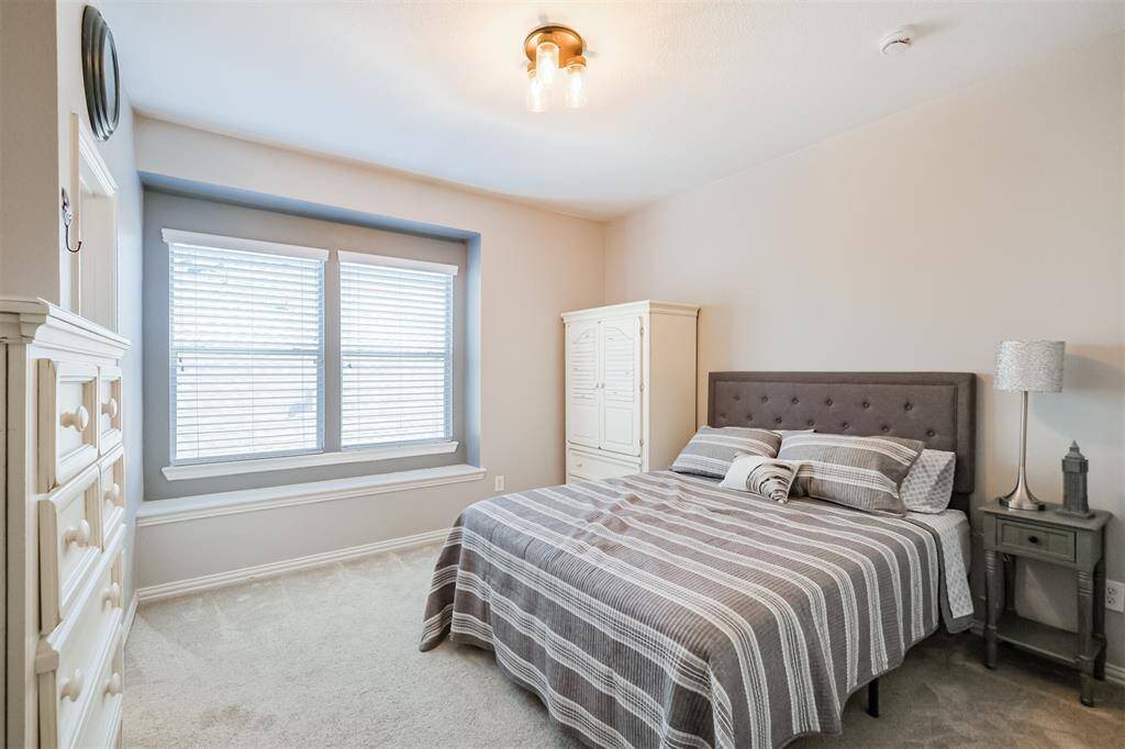 Bright and inviting, the third upstairs bedroom boasts large double windows.