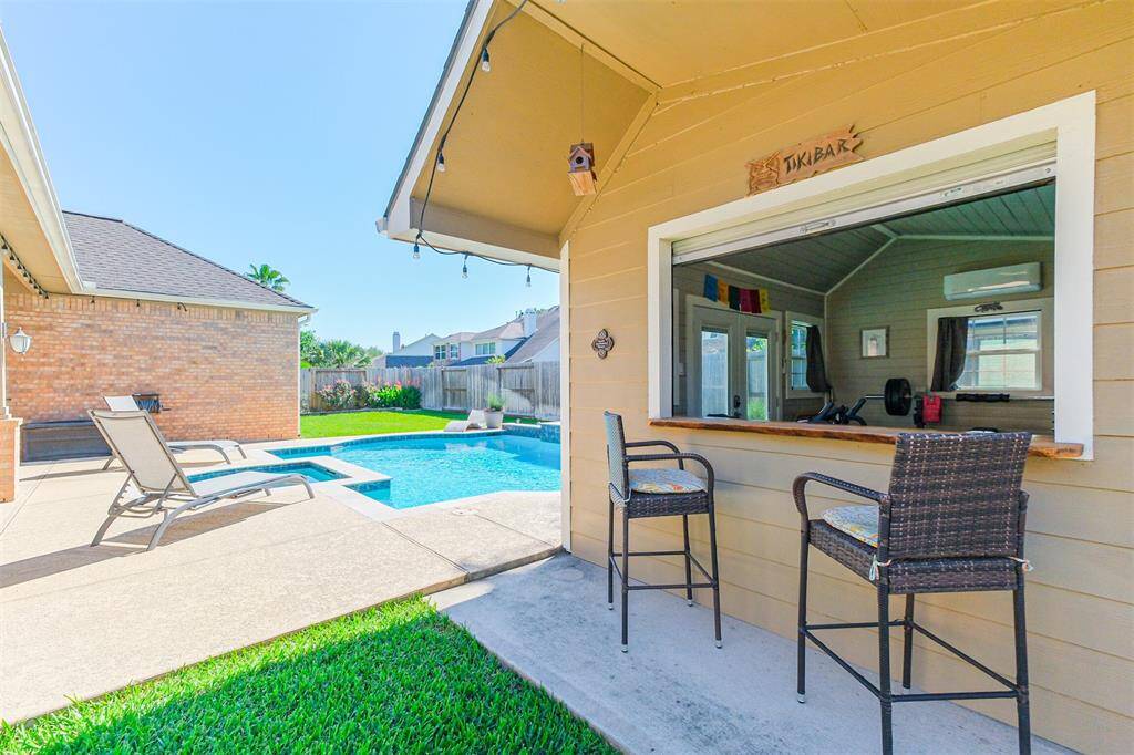 Enjoy poolside relaxation with a convenient bar top and roll-up door in the pool house.