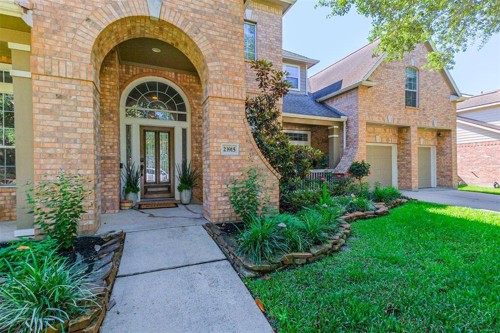 Experience timeless elegance of the front entrance with a striking brick archway and a beautifully stained front door with leaded glass inserts.
