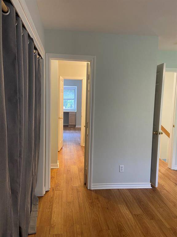 View from the second bedroom, through the bathroom, to the primary room's desk area.