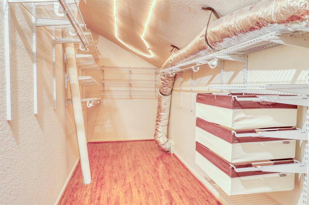 The primary suite features an enormous walk-in closet with lots of built-in storage.