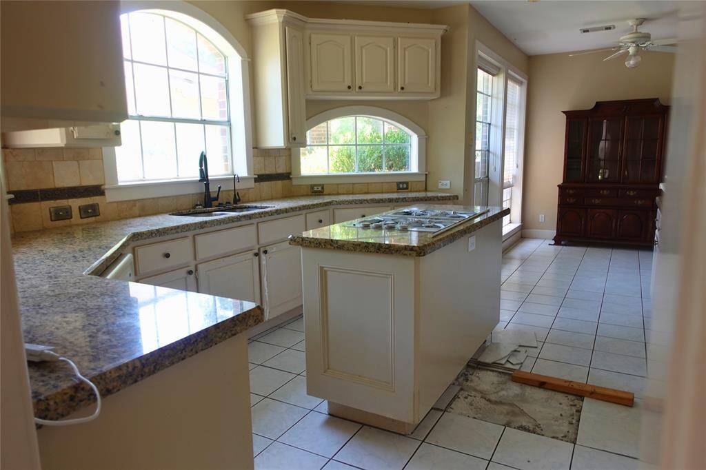 Kitchen with Granite Counters and Island Cooktop