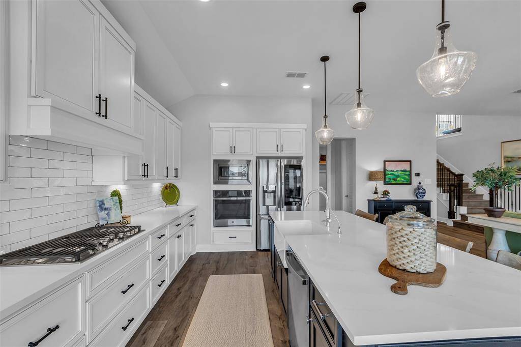 GE Profile stainless steel appliances and a five-burner gas cooktop.