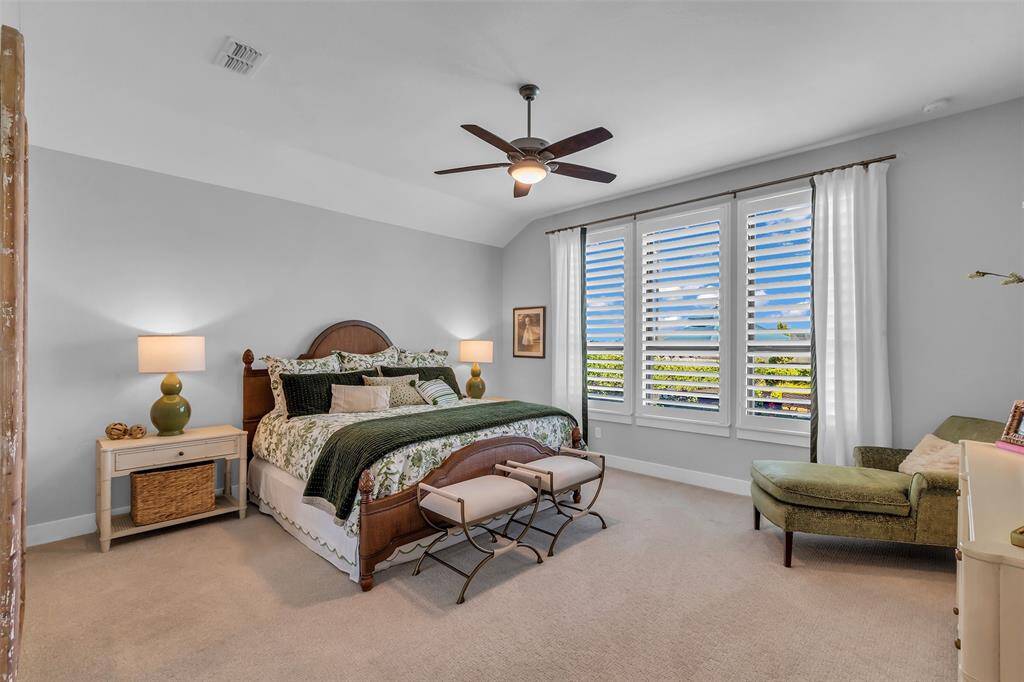 The first-floor primary with plantation shutters and plush upgraded carpet.